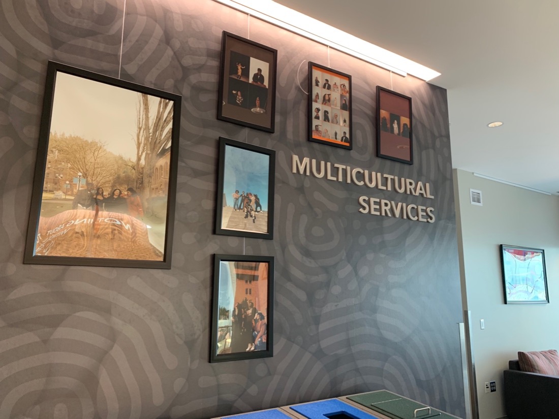 Framed photos next to a &quot;Multicultural Services&quot; sign