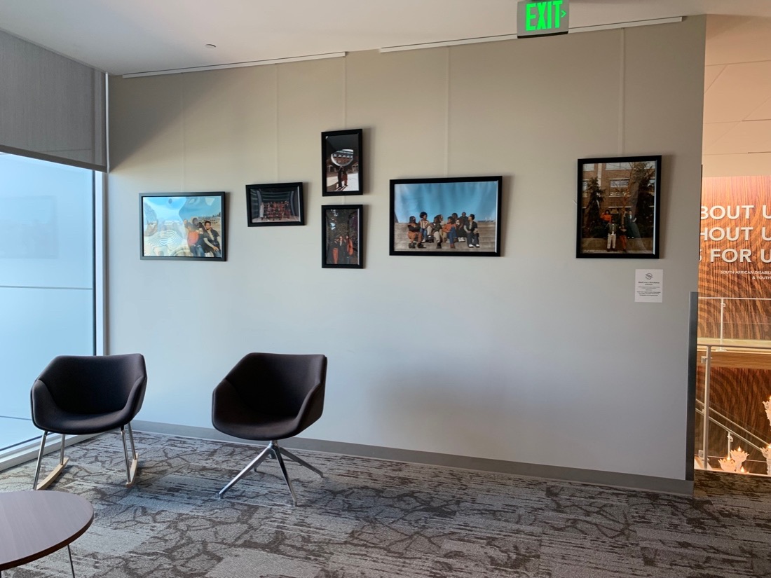 Photos on a gray wall next to open seating