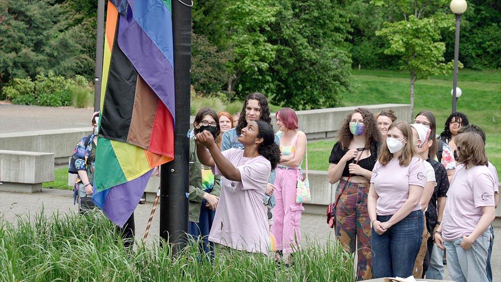 Students raising a Pride flag